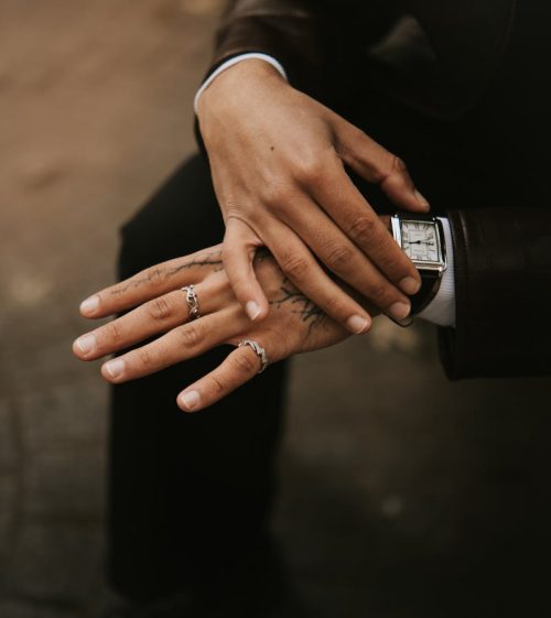 Close-up portrait of a fashionable man with tattoos and rings in Lille, France.